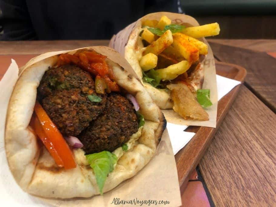 Falafel pita and chicken gyro on wooden tray at OPA in Tirana