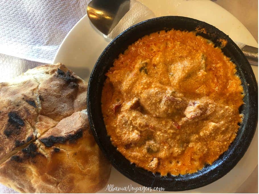 round dish of Fergese Verore on white plate with crusty round bread beside it
