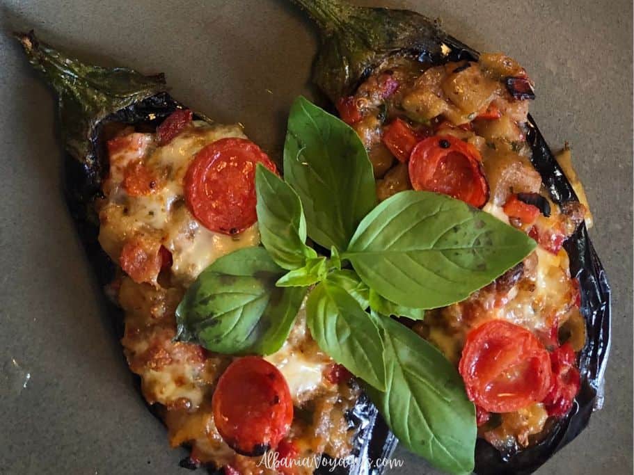 close up of Patëllxhane të Mbushur on grey plate garnished with basil leaves