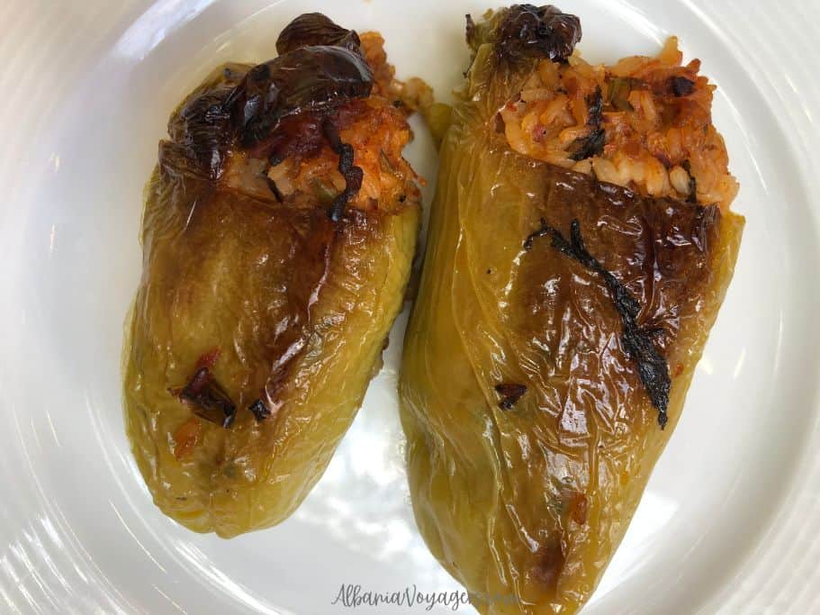 white plate with 2 large stiffed green peppers, one of the best things to eat in Tirana
