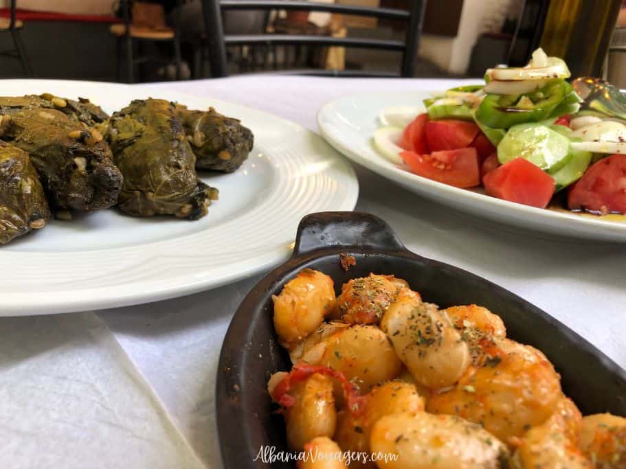 plates of japrak, vegetable salad and fasule on white paper tablecloth at Oda Restaurant in Tirana