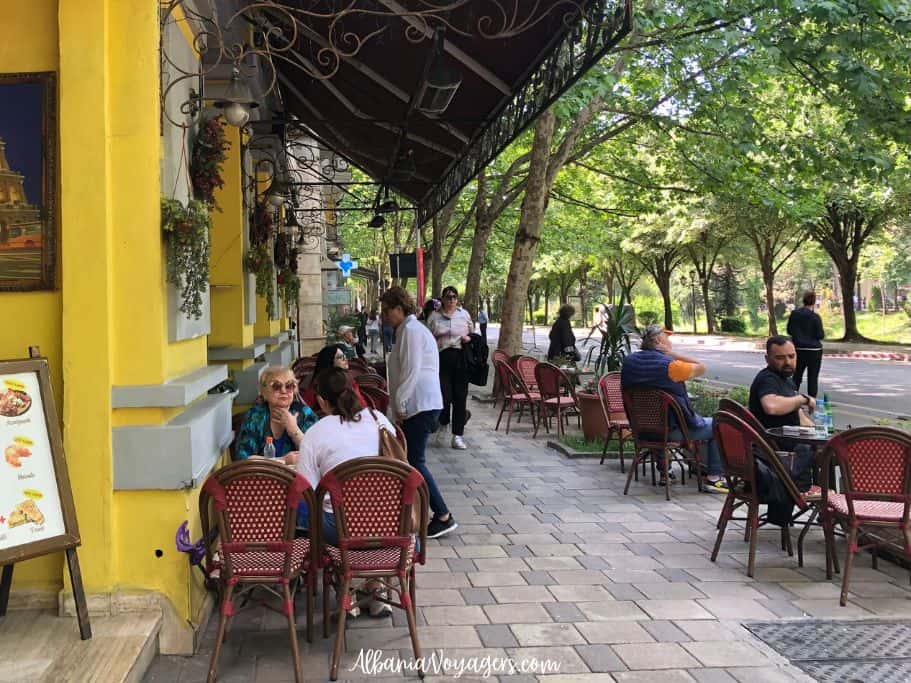outdoor cafe with tables and people drinking coffee in Tirana
