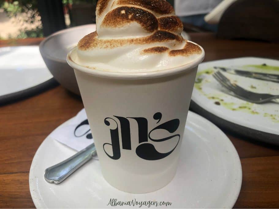 a big white mug with restaurant log and burned white marshmallow topping on top at In's Myslym Shyri 