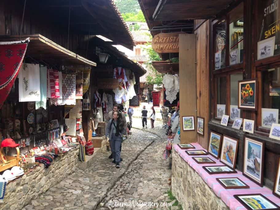 in Kruja Bazaar with shops on both sides and people walking through