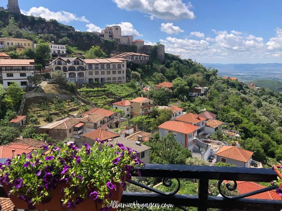 view from balcony with flowers of Kruja town on mounain with castle in background