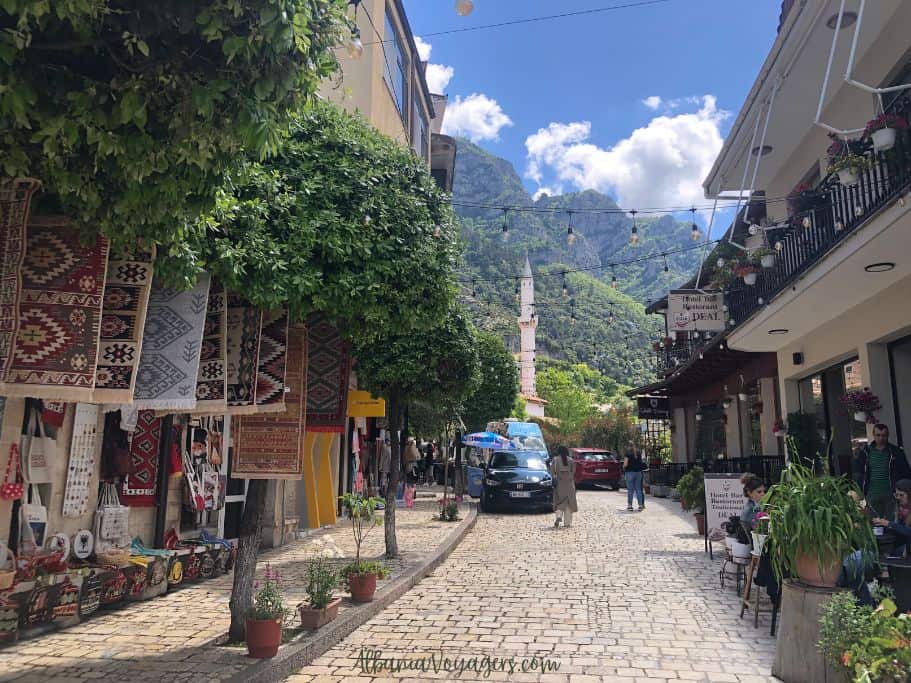 cobblestone street in Kruja, Albania  with mountains in backbround and minaret