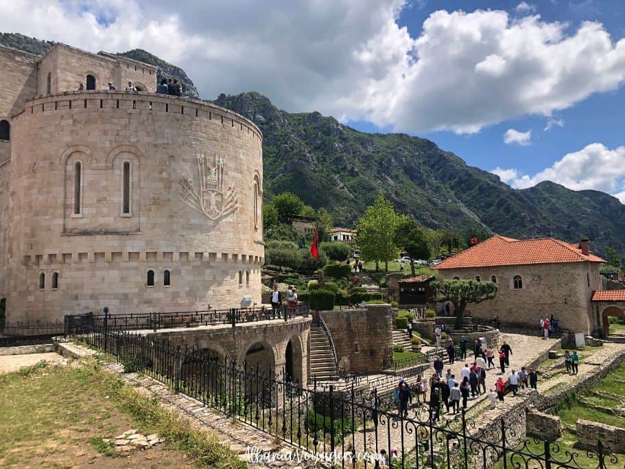 exterior view of Castle of Kruja grounds with mountains behind and clouds in the sky