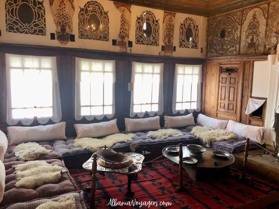 inside main salon with rugs and large cushions on floor and copper table in Gjerge Kastrioti Museum of Kruja