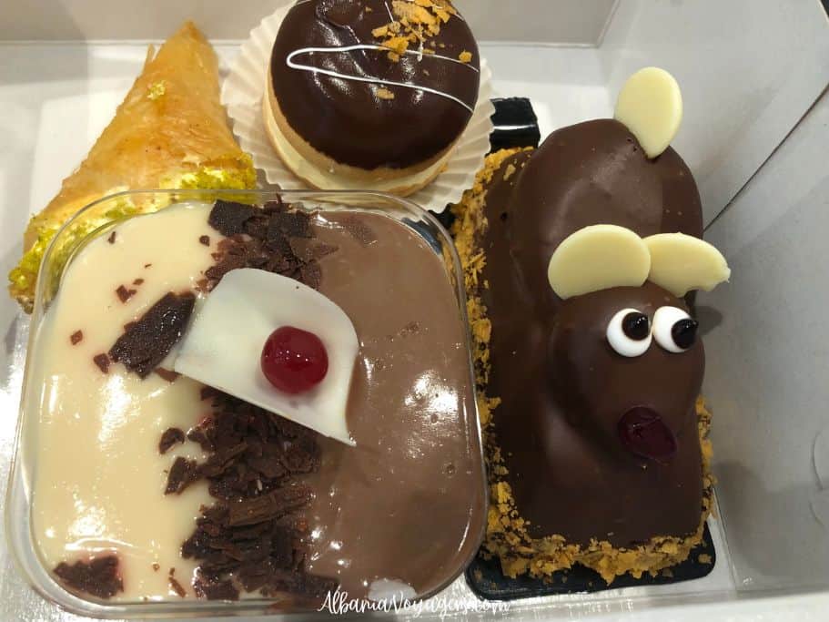 white pastry box with 4 fancy pastries inside, including one shaped like a mouse