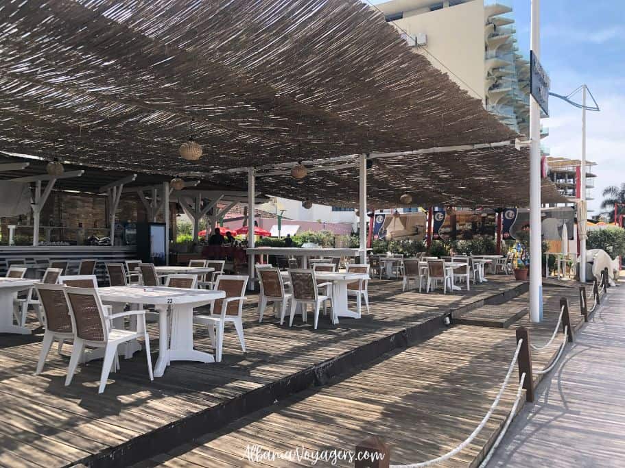 beachfront restaurant with white talbes and chairs and bamboo canopy in Golem