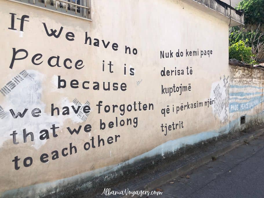 Mother Teresa quote "If we have not peace it is because we have forgotten that we belong to each other" on side of building in Tirana