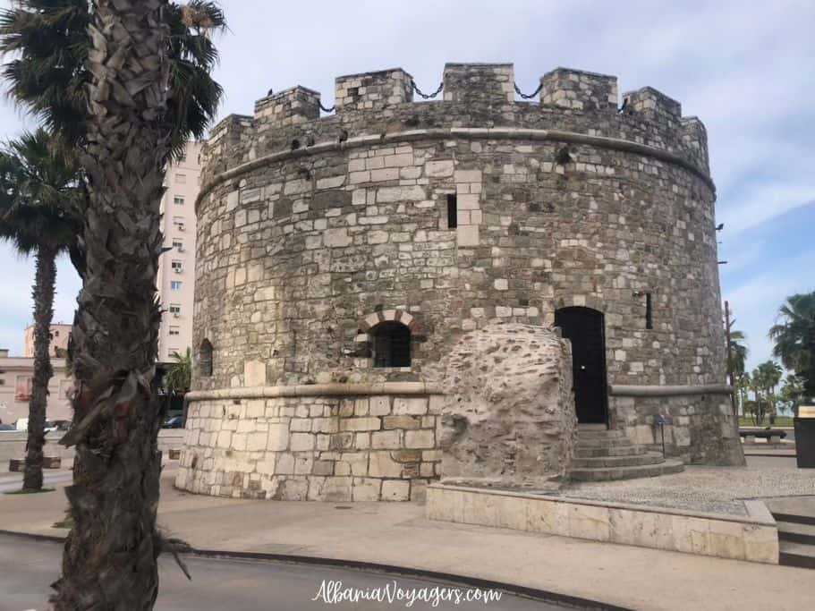 stone watchtower with palm trees around in Durres