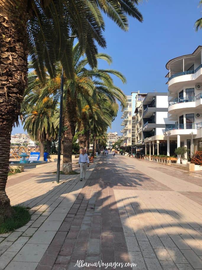 beachfront promenade in Sarand with palm tees and people walking