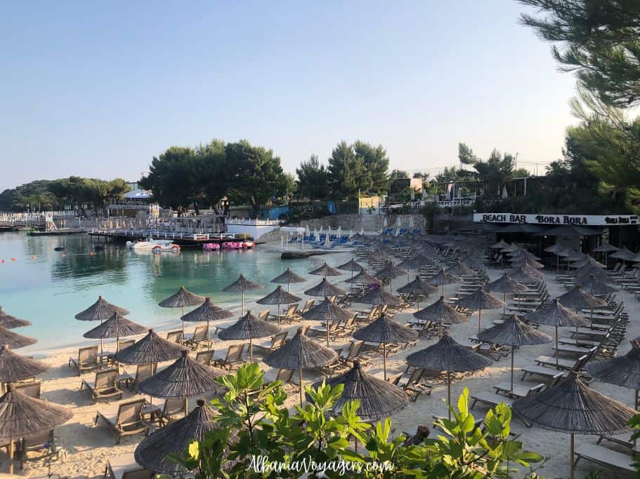 Bora Bora Beach in Ksamil with rows of beach chairs and rattan umbrellas