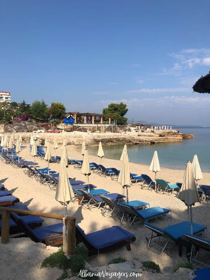 Jonian Beach with rows of blue sunbeds in Ksamil
