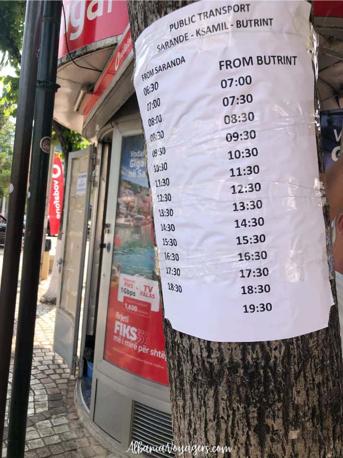 close up of the Ksamil - Butrint bus schedule taped to a tree in Saranda