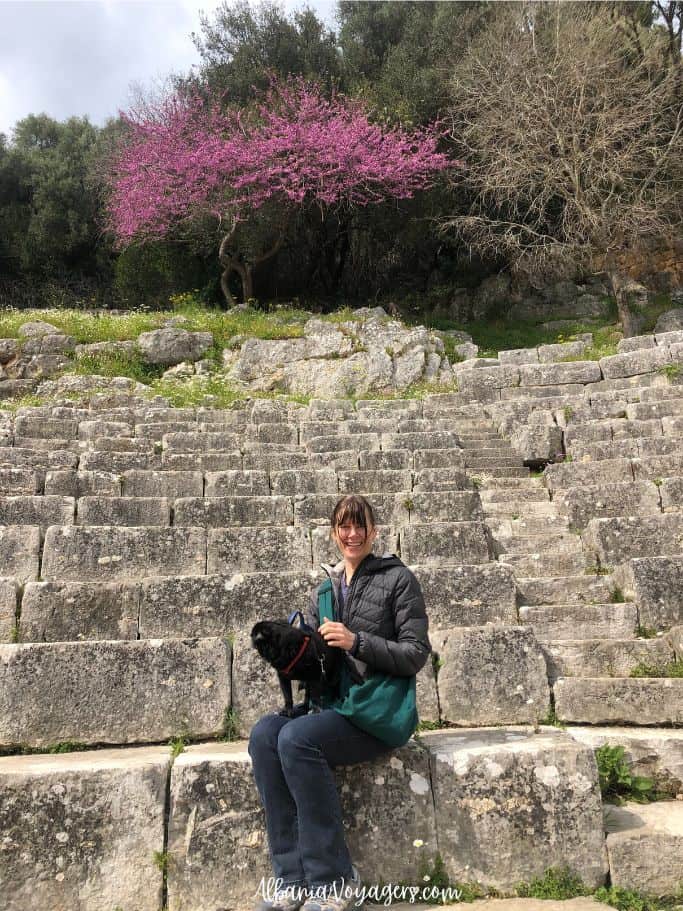 the author and her dog sitting in the ancient theatre at Butrint when visiting