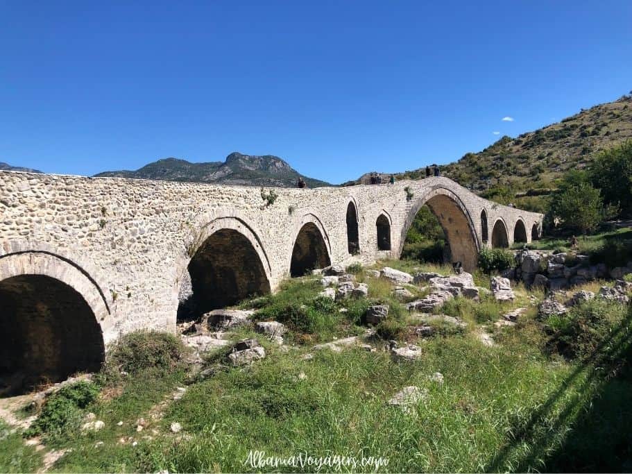 arched stone Mesi bridge with grass underneath