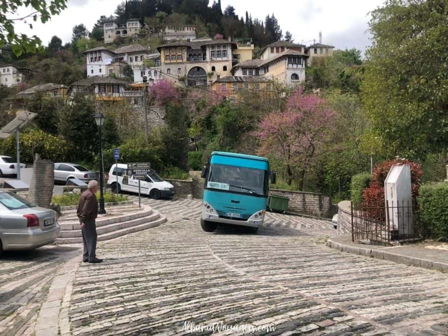 blue bus on cobblestone street in Gjirokaster