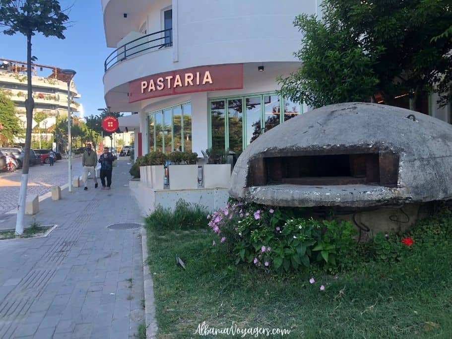 concrete bunker with flowers in front beside a restaurant in Saranda 