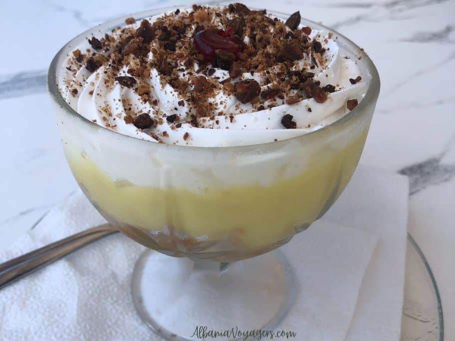 close up of glass dessert bowl filled with custard and whipped cream, zup