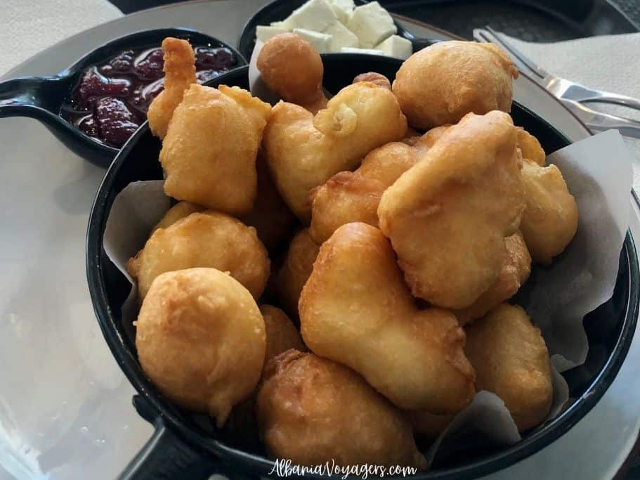 black dish of fresh petulla with cheese and jam, a traditional Albanian food
