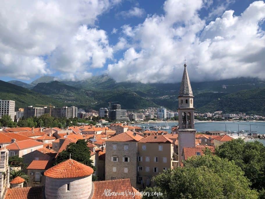 elevated view of red clay roofs on Budva's old town with sea and mountains