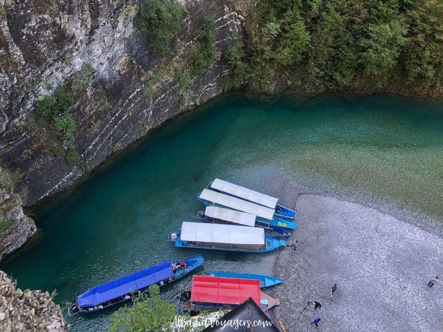 over view of blue and red long boars docked on Shala River