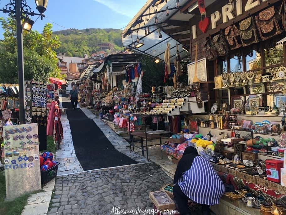 middle of bazaar in Prizren with stalls on right and mountains behind