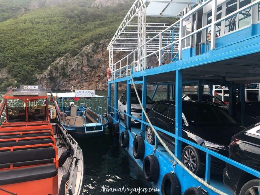 several boats and car ferry on Lake Komani