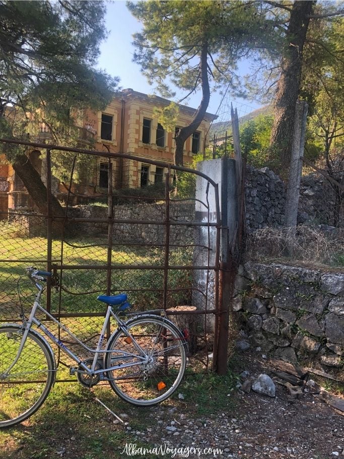 gated King Zog villa with bike chained to it in Shiroka
