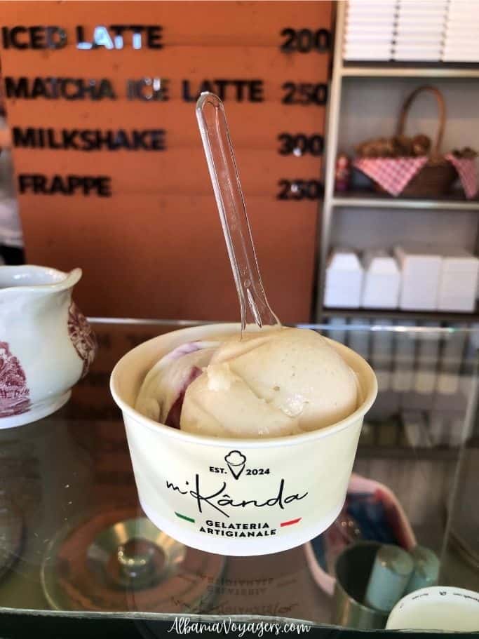 2 scoops of gelato in a white cup with spoon at M'Kanda in Shkoder