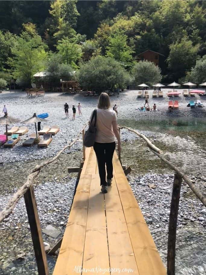 author crossing the Shala River on little wooden bridge
