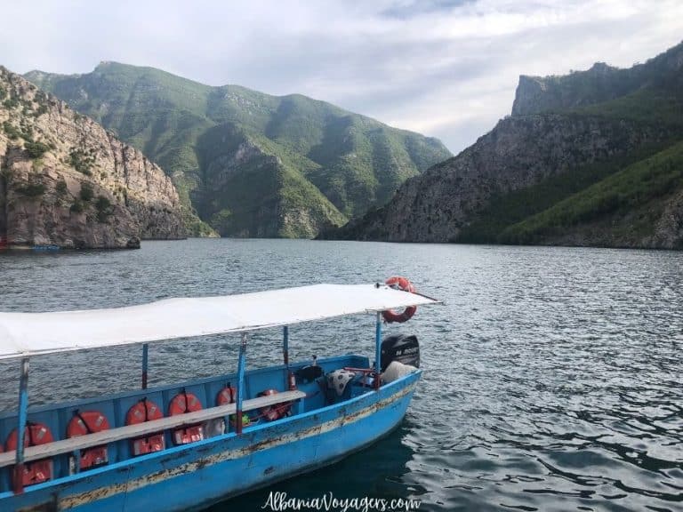 blue passenger long boat on Lake Komani