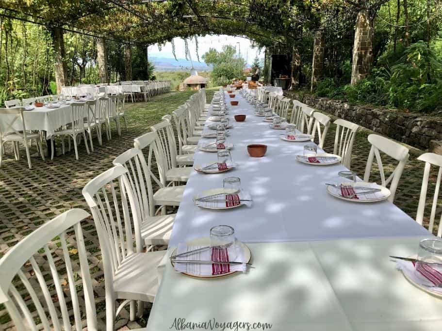 long table set with wite cloth and red and white woven napkins at Mrizi i Zanave