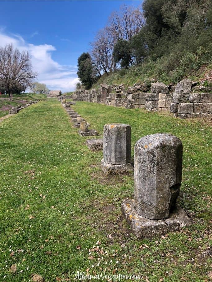 ruins of stone portico in field with blue sky