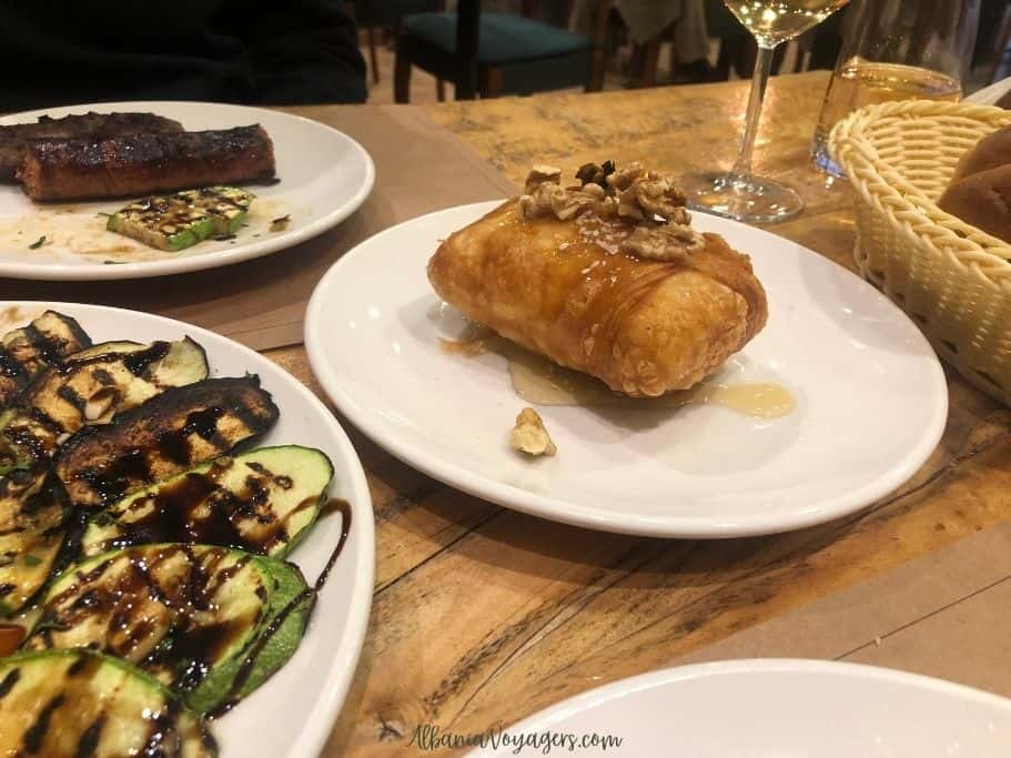 plates of phylo wrapped feta, grilled vegetables and sausages at Trifilia in Permet