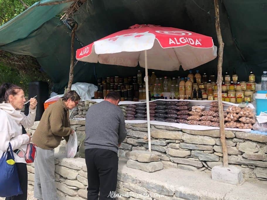 stand selling local items with people sampling and shopping