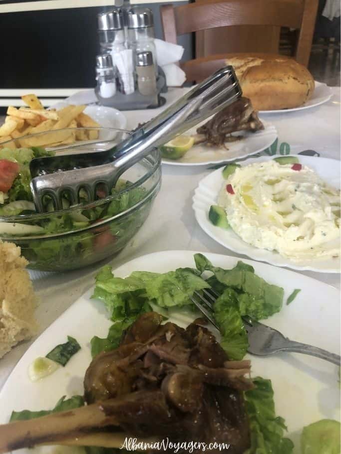 plates of grilled lamb, tzatziki, bread, potatoes, and bowl of salad at Restorant Aned in Permet
