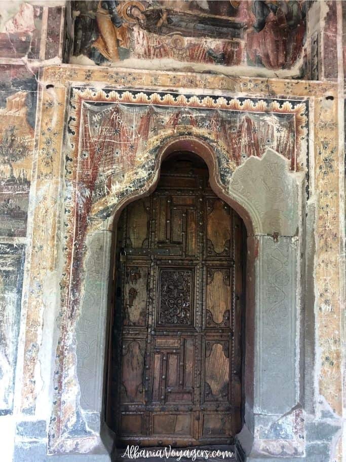entrance door to Saint Mary's Church in Leus with frescoes around it