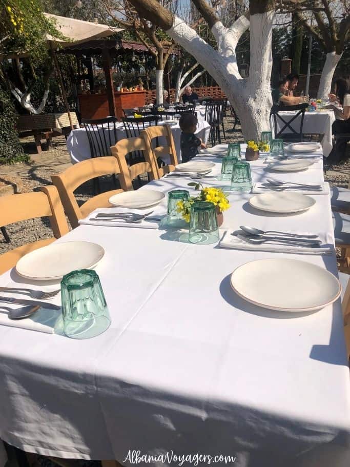 outdoor dining table with white tablecloths and floweres at Blerina Farm, one of the top agritourism in Albania