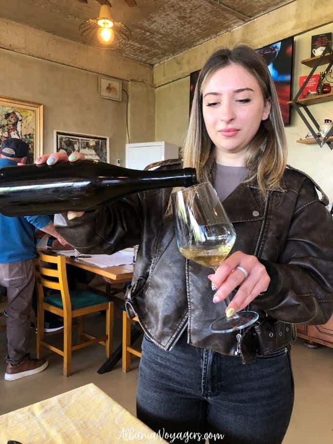 young woman pouring white wine at Kantina Balaj on Vlore wine route in Albania