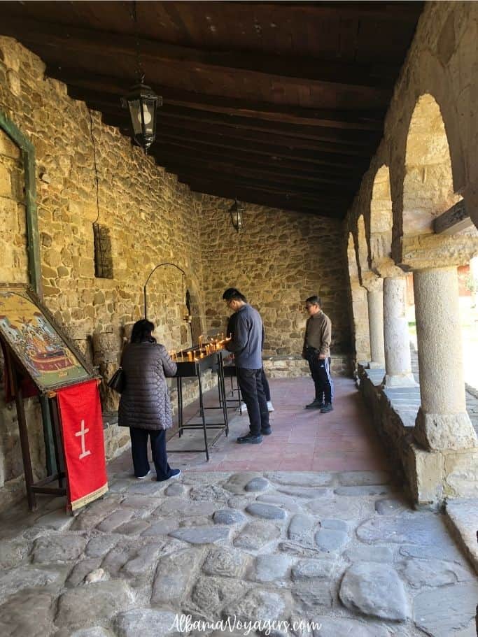 group of adults lighting candles outside St. Mary's on Zvernec Island