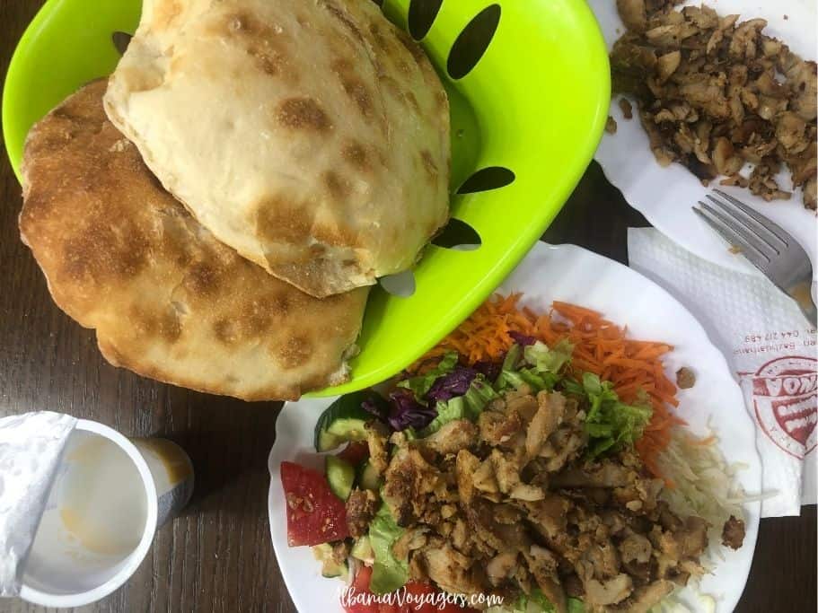 gyro plate and green bowl of pitalke bread in Prizren