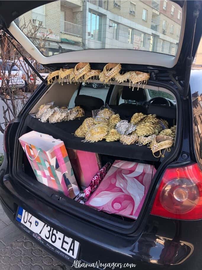 black hatchback car open displaying traditional ladies beaded and lace garments