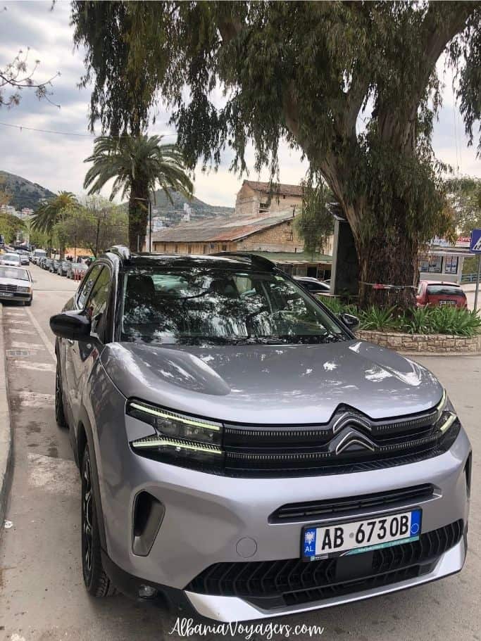 grey SUV car rental on road in Saranda, Albania